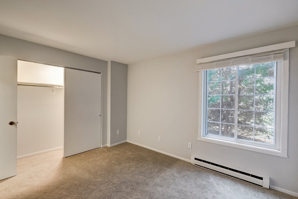 a bedroom with a large window and a closet