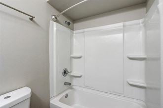 a white bathroom with a shower and a toilet
