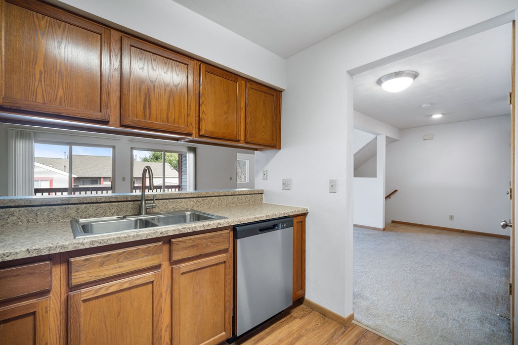 a kitchen with wooden cabinets and a sink and a window