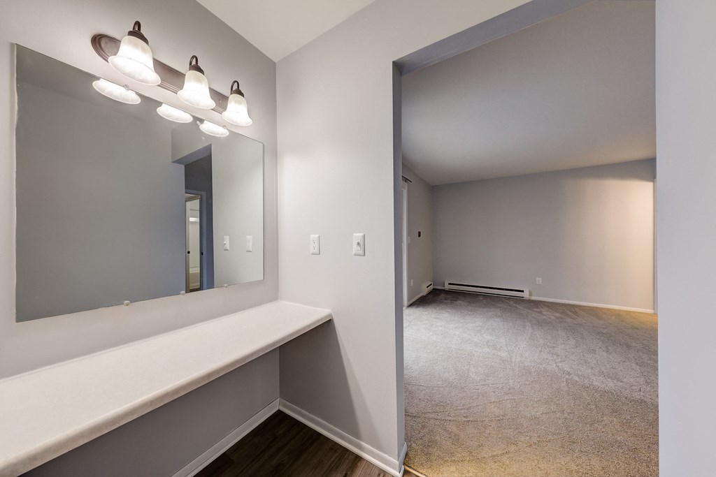 a bedroom with a desk and a mirror