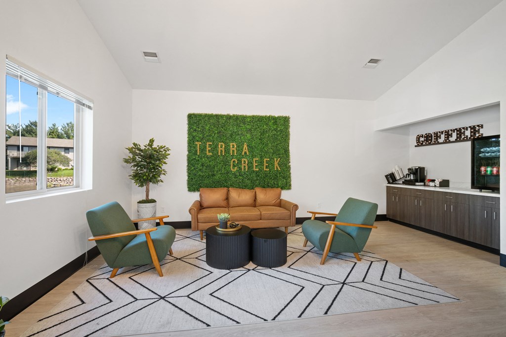 a living room with a couch and chairs and a green rug