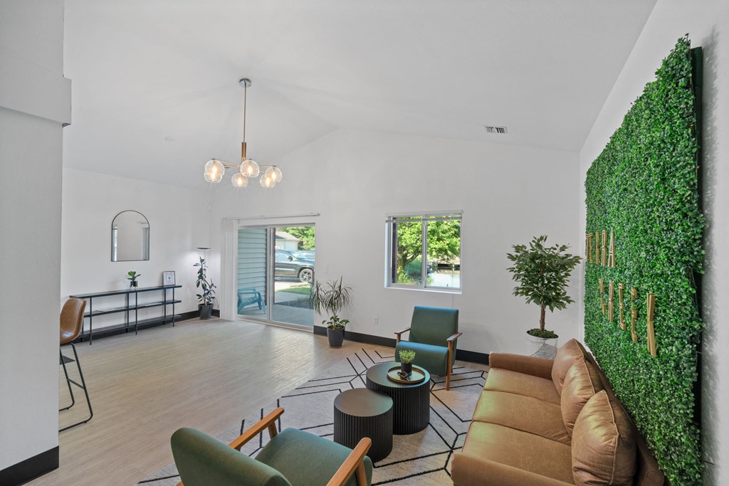 a living room with a couch and chairs and a green wall