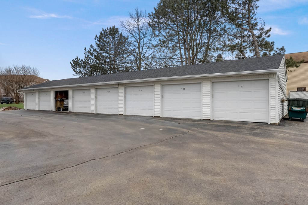a large white garage with a garage door open in front of it
