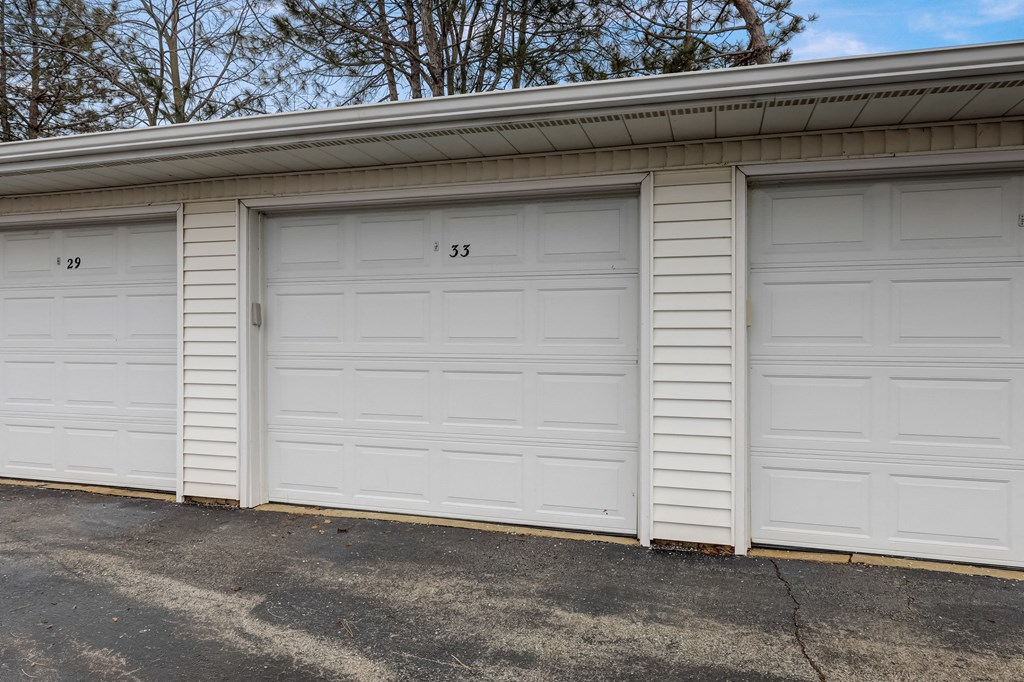 a row of three garage doors in a parking lot