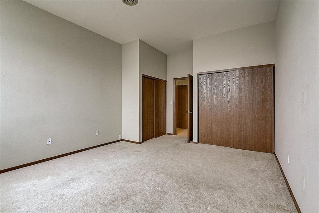 a bedroom with a carpeted floor and a closet