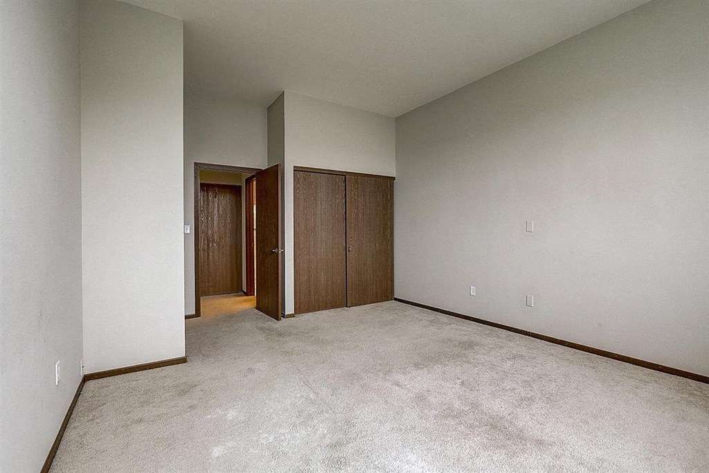 an empty living room with a door to a hallway