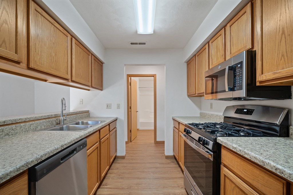a kitchen with granite counter tops and wooden cabinets