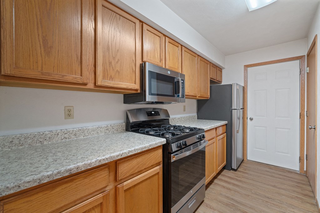 a kitchen with wood cabinets and granite counter tops and stainless steel appliances