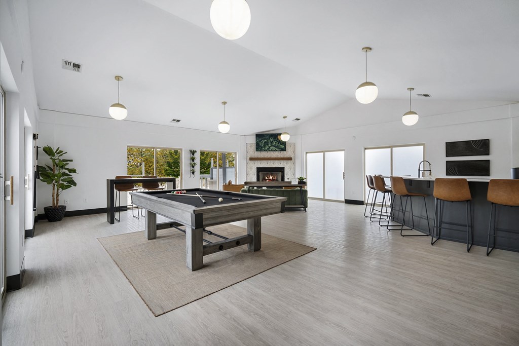 a large living room with a pool table and a bar
