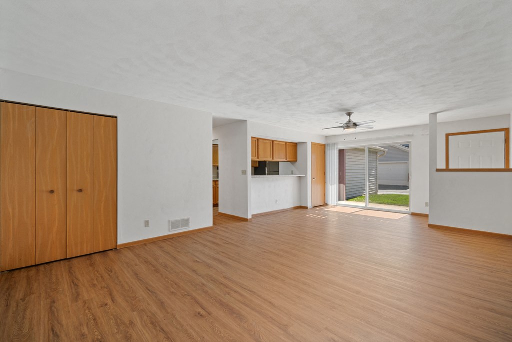 an empty living room with wood floors and white walls