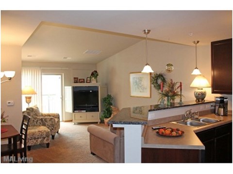 A living room with a couch, chair, and television.