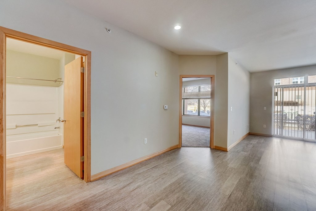 the living room and dining room of an empty house with wood flooring