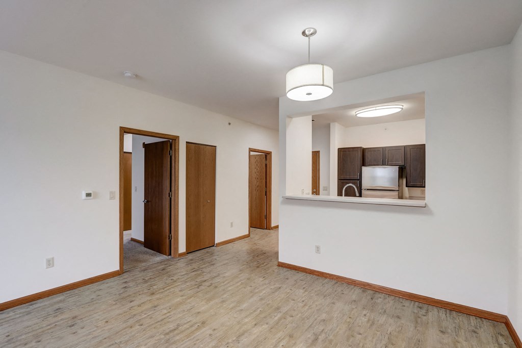 an empty living room with white walls and wood flooring