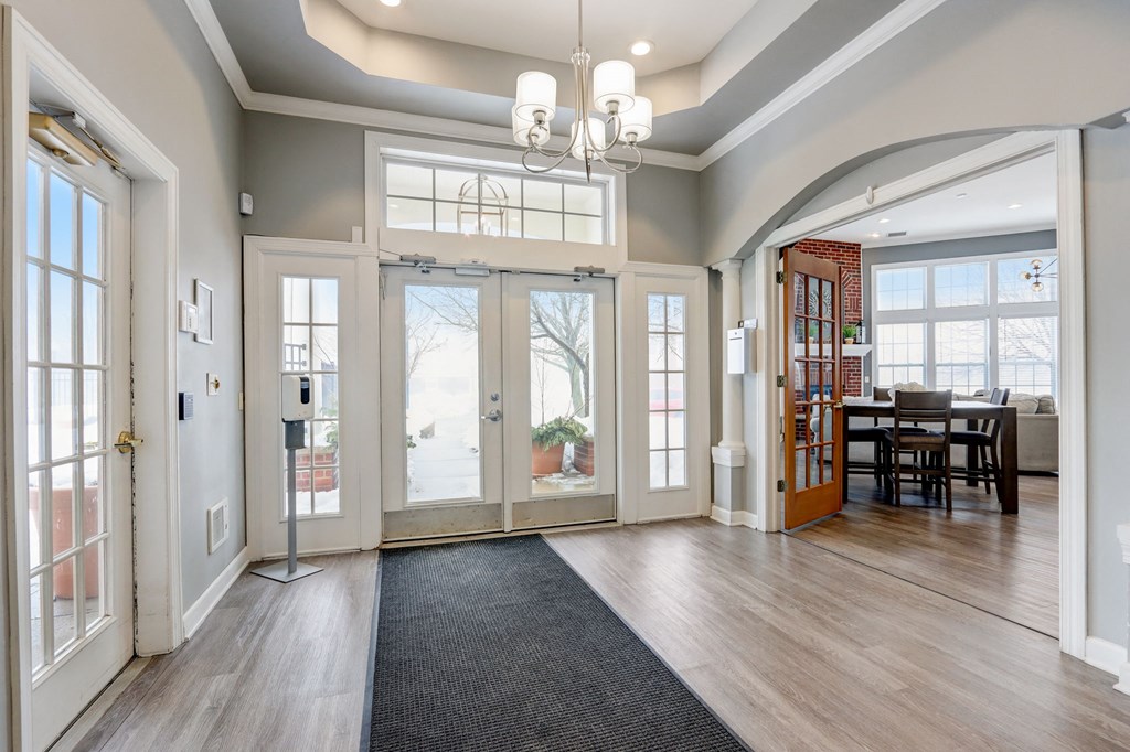 an empty living room with glass doors and a dining room table