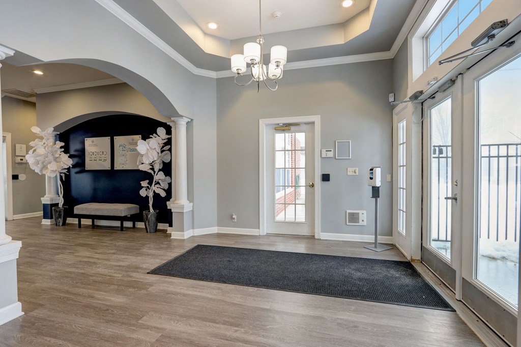 a large foyer with a black couch and a chandelier