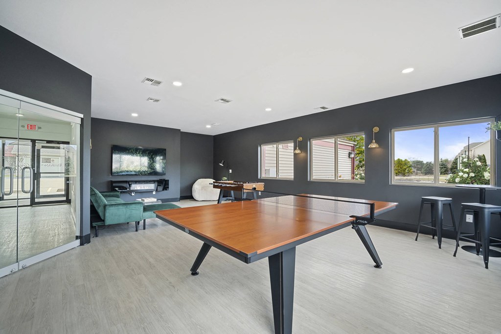 a games room with a ping pong table and a tv