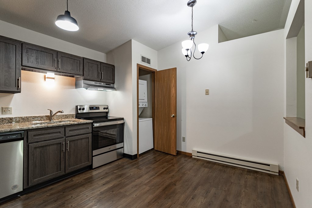 the view of a kitchen and living room in an empty apartment