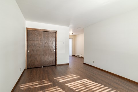 a living room with a wooden door and a hard wood floor