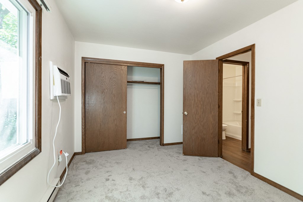 an empty room with two doors and a window