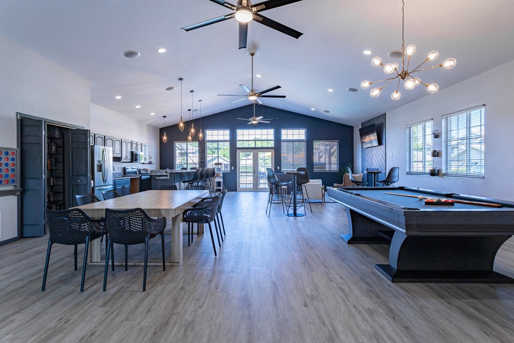 a spacious game room with a pool table and dining area