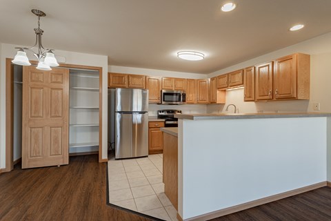 a kitchen with a white island and a stainless steel refrigerator