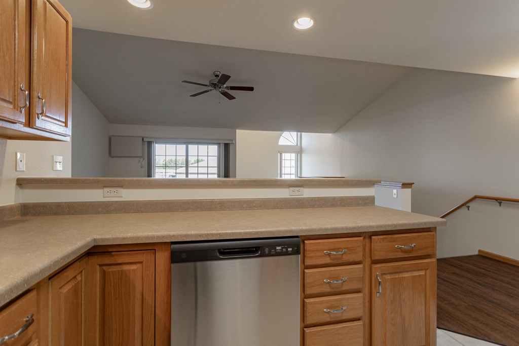 an empty kitchen with a counter top and a dishwasher