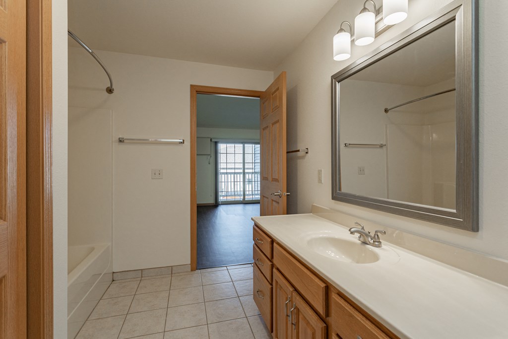 a bathroom with a large mirror and a sink and a shower