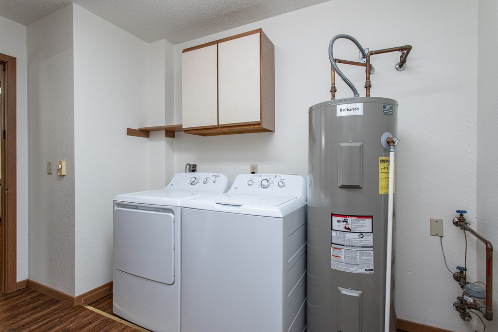 a small laundry room with a washer and dryer and a water heater