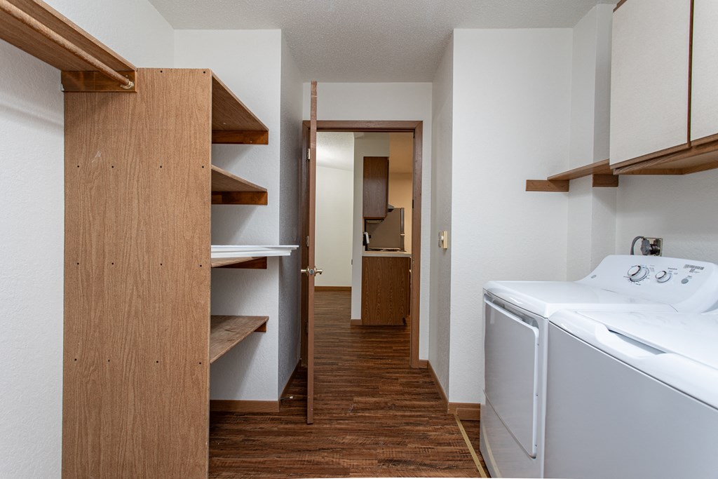 a laundry room with a washer and dryer and a hall to a bathroom