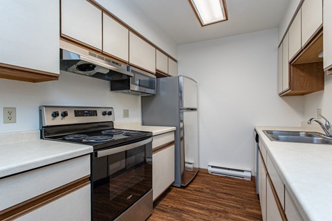 a kitchen with white countertops and stainless steel appliances