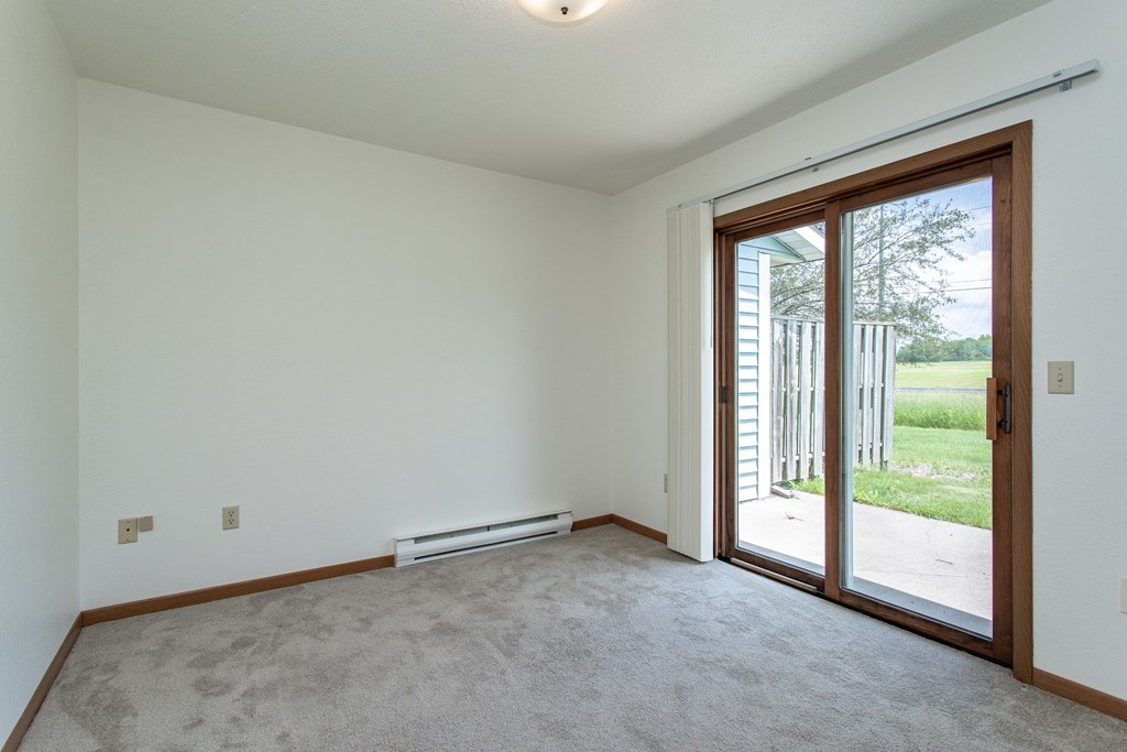 an empty living room with two large windows