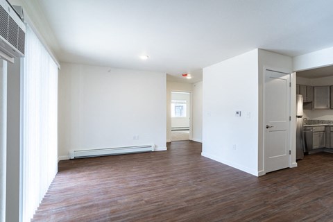 a living room with white walls and a wood floor