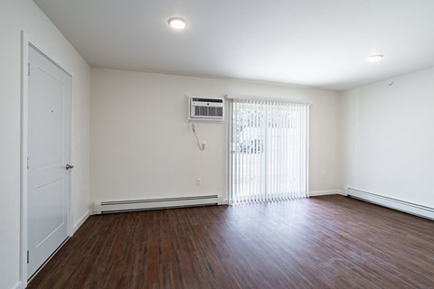 the living room of a home with a wood floor and white walls