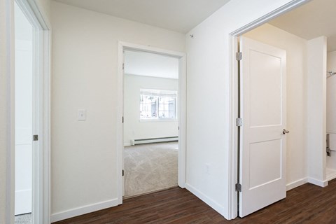 a bedroom with a door open to a living room