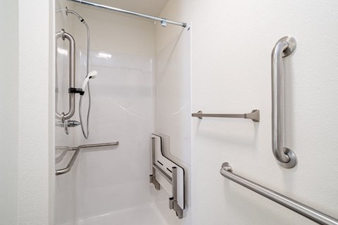 a view of a bathroom with stainless steel handrails on the wall