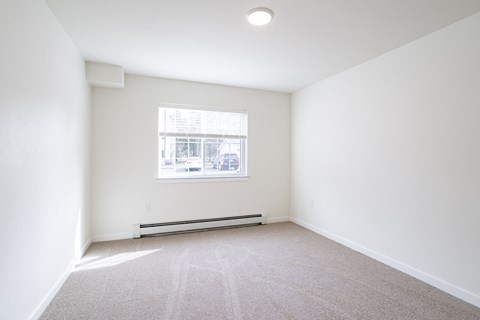 an empty room with white walls and a window