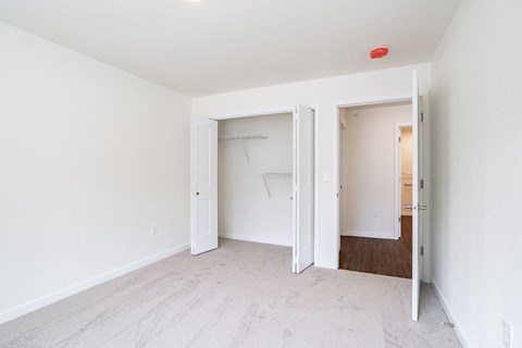 an empty bedroom with white walls and a closet