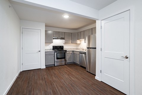 a renovated kitchen with stainless steel appliances and white doors