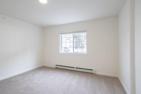 an empty room with white walls and a window