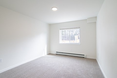 an empty room with white walls and a window