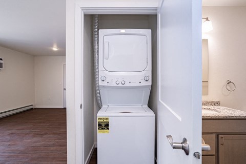 a white washer and dryer in a room with a door