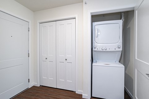 a small laundry room with a washer and dryer and white doors