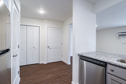 a renovated kitchen with granite counter tops and stainless steel appliances