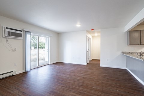an empty living room with white walls and a sliding glass door