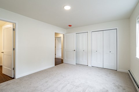 an empty living room with white walls and white doors