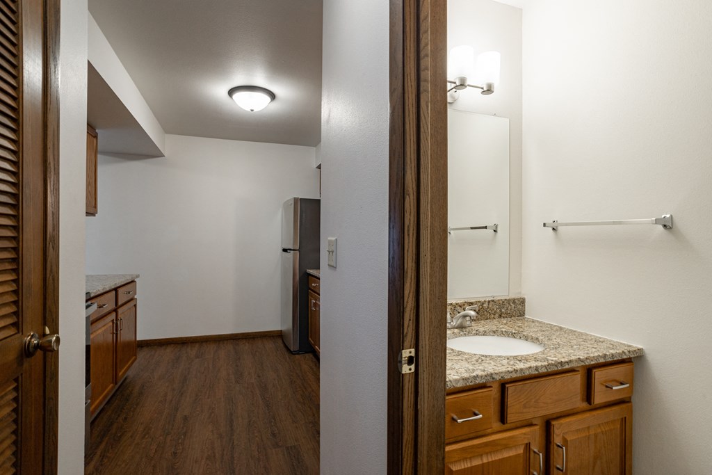 the view of a bathroom with a sink and mirror from a doorway