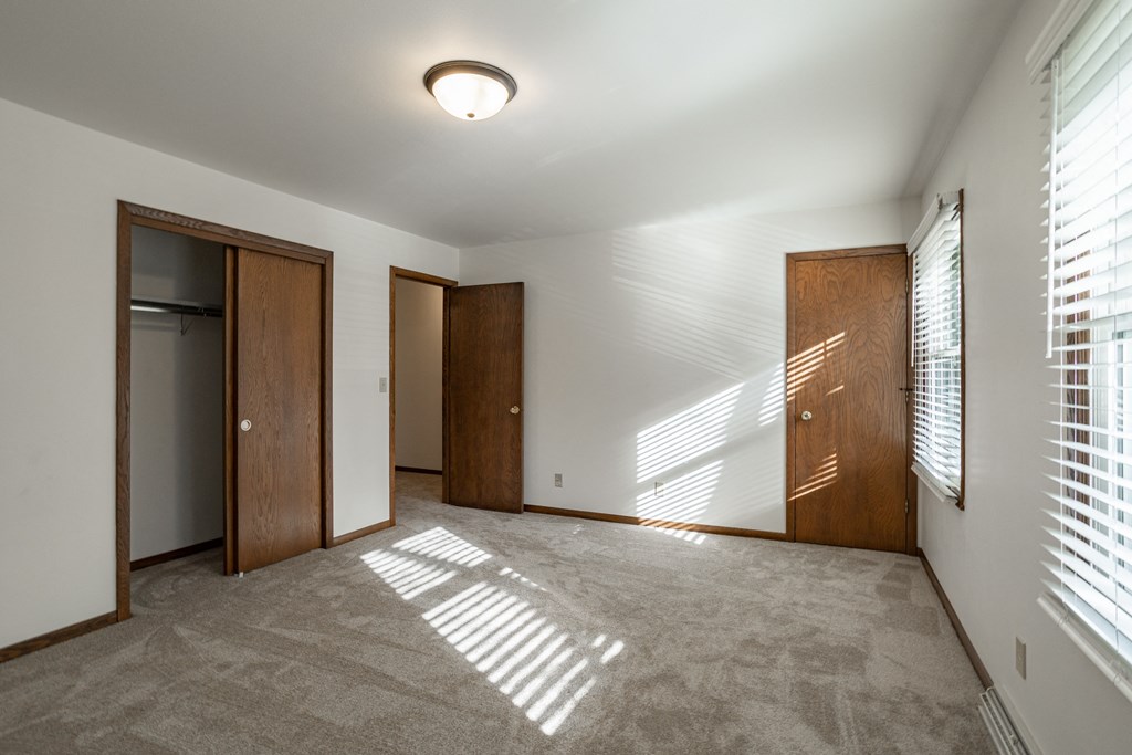 an empty living room with two doors and a window