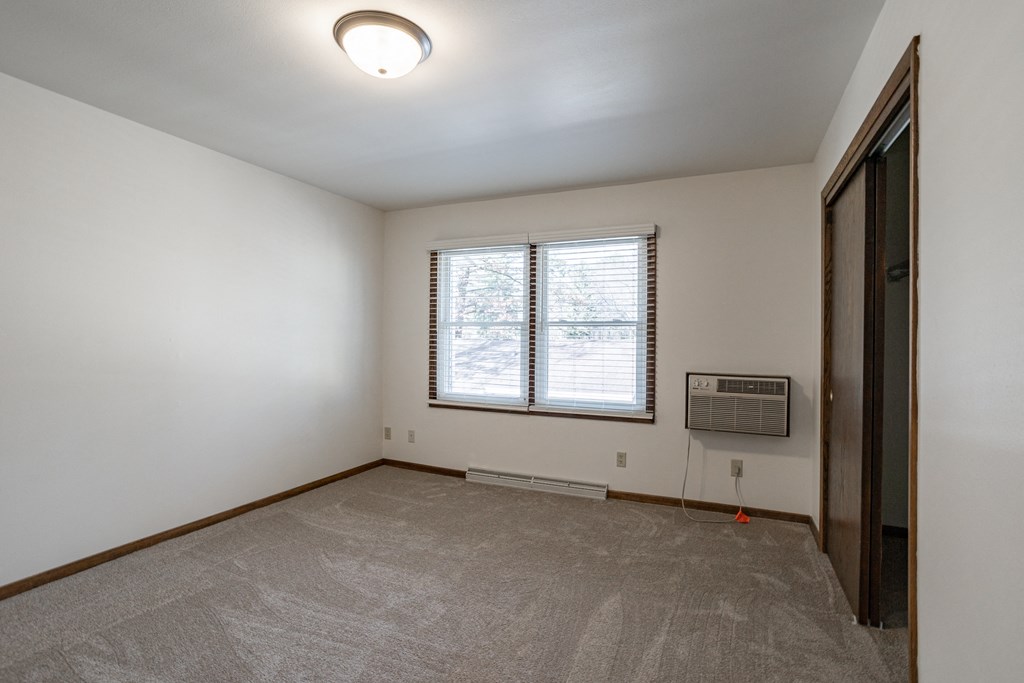 an empty living room with a window and a door