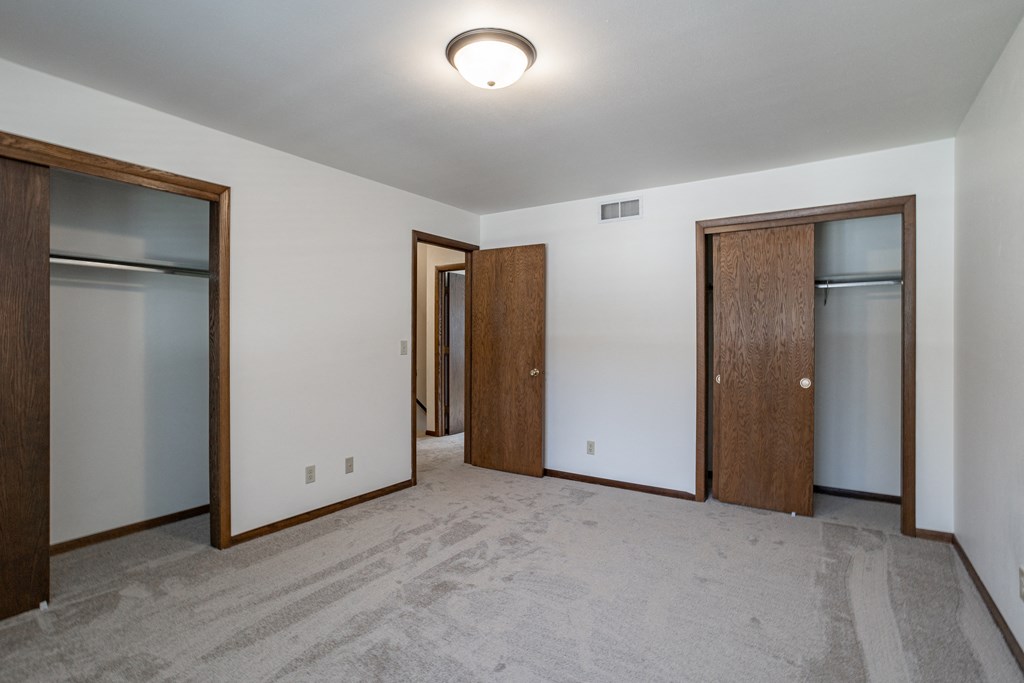 an empty room with three closets and three doors