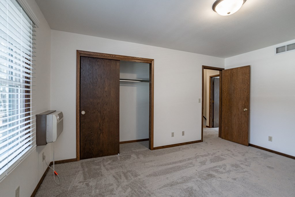 an empty living room with a tv and a door to a closet